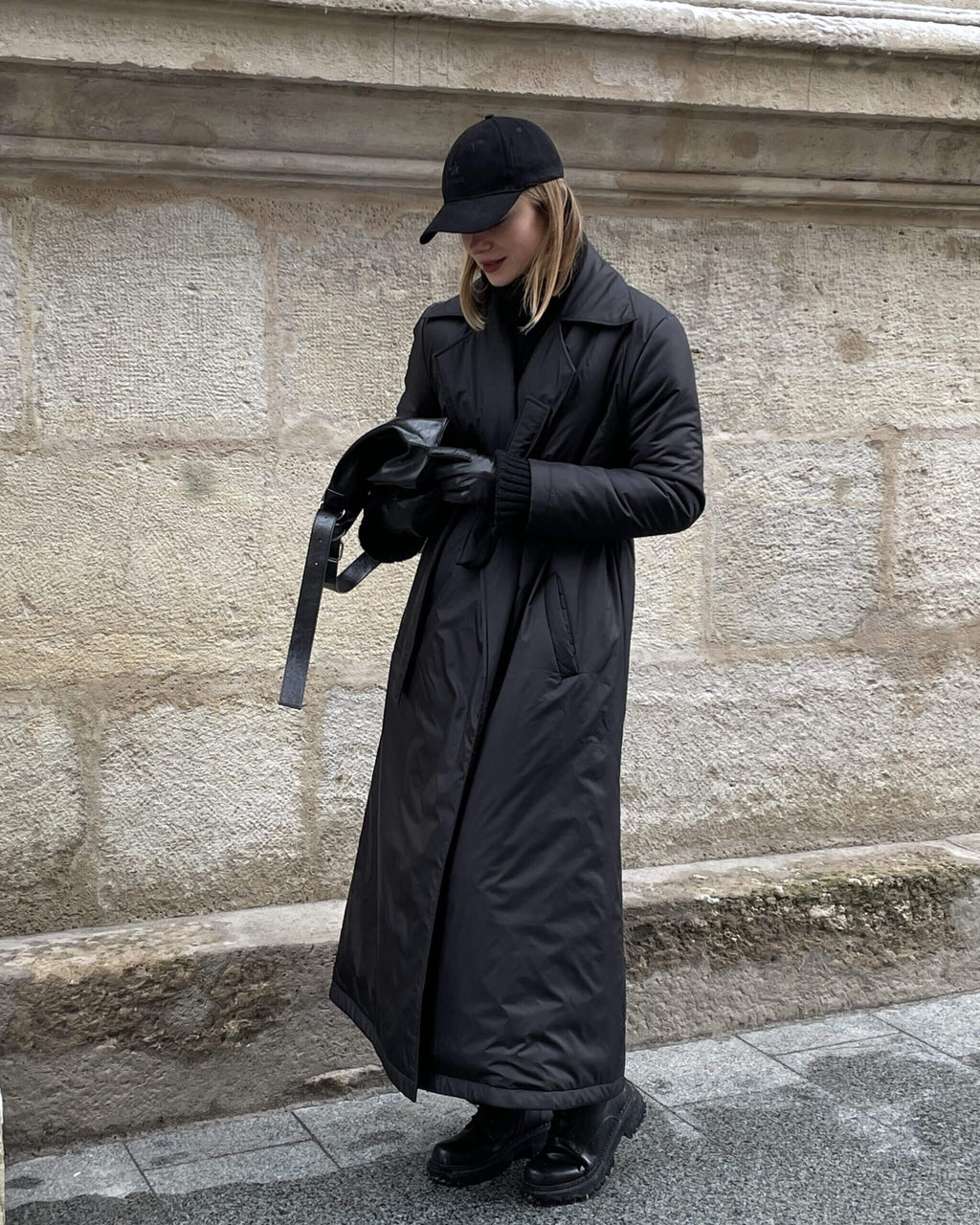 темне довге стьобане пальто-тренч на жінці, теплий зимовий верхній одяг з високою горловиною, стильний бежевий пуховик для міста.